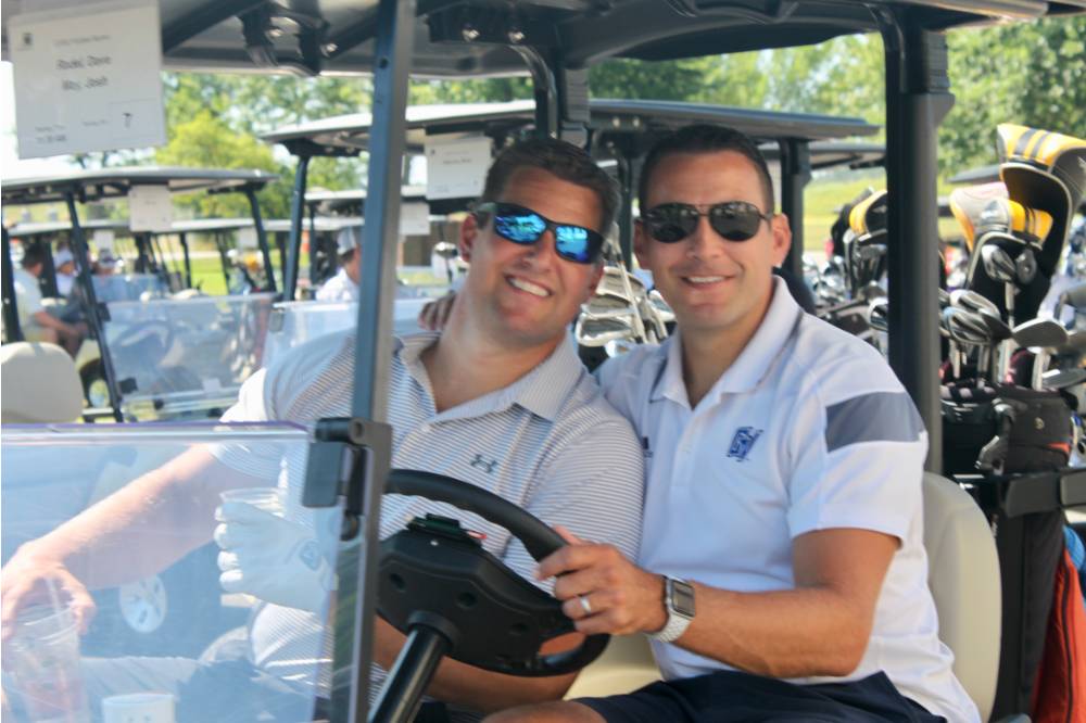 2 alumni in golf cart